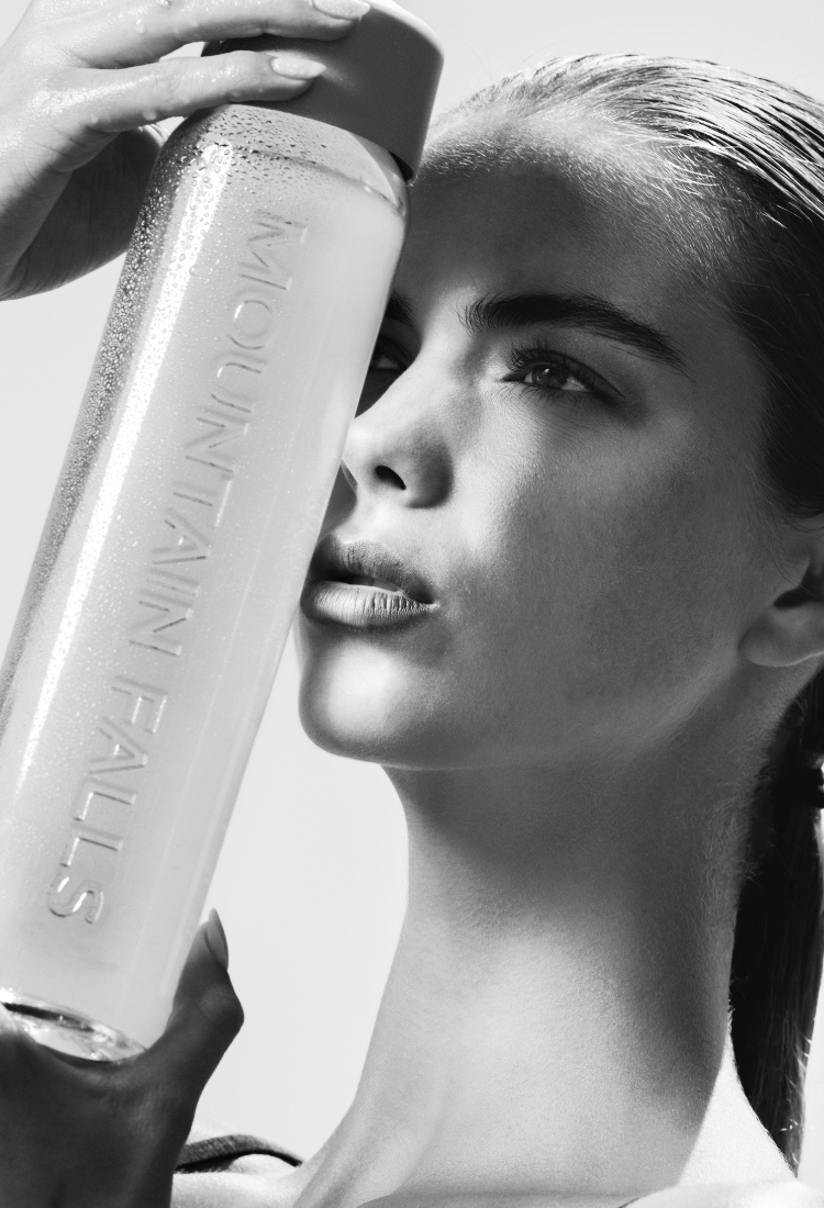Model holding mountain falls sparkling water