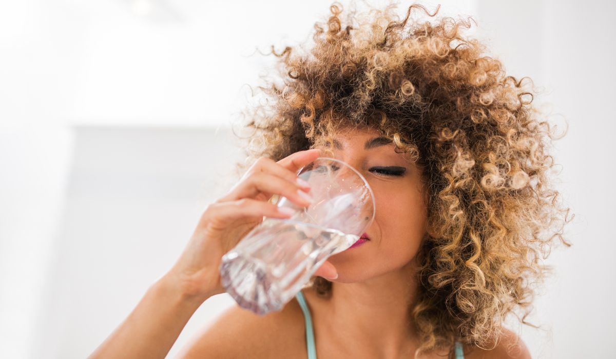 lady drinking still water from a glass